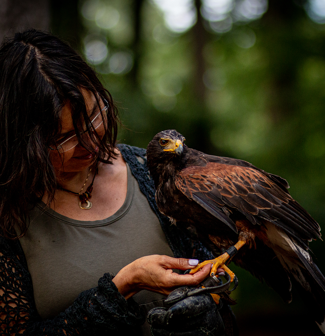 Lächelnde Frau mit einem Falken auf der Hand